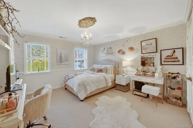 a bedroom with a large bed and a chandelier