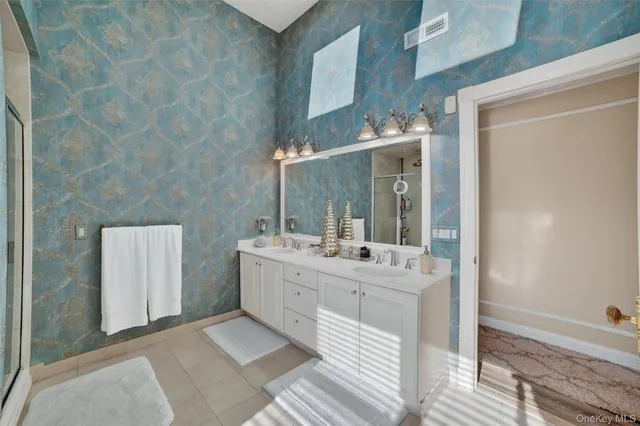 a bathroom with double vanity sink and a mirror