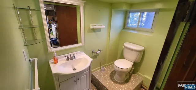 a bathroom with a toilet sink and mirror