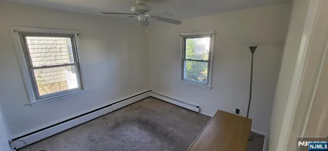 an empty room with windows and fan