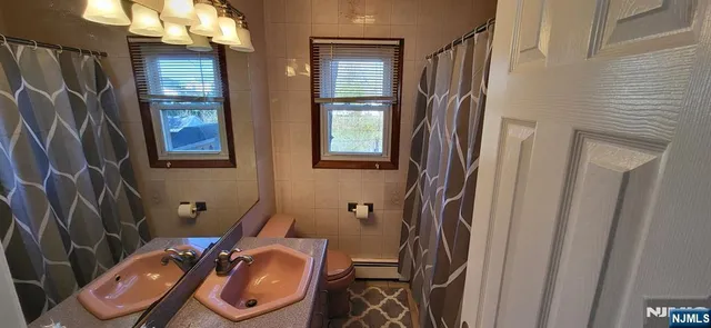 a bathroom with a sink toilet and mirror