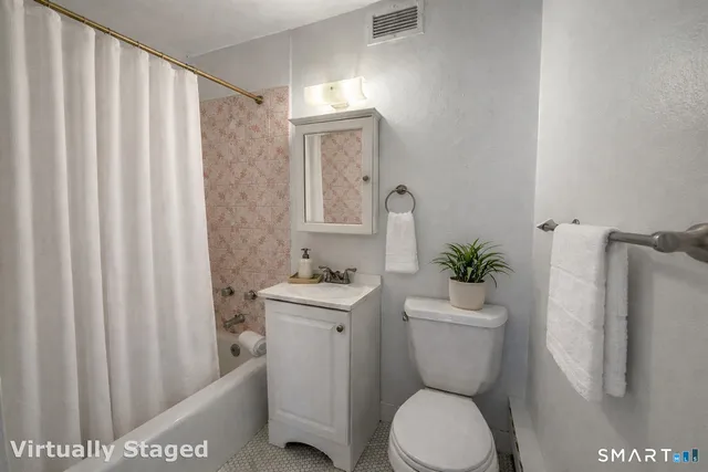 a bathroom with a toilet a sink and a mirror