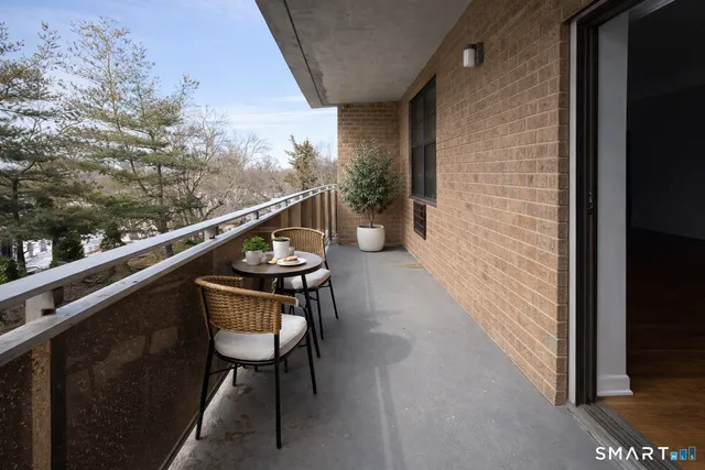a balcony with wooden floor and outdoor seating