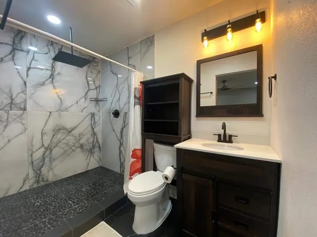 a bathroom with a sink toilet and shower