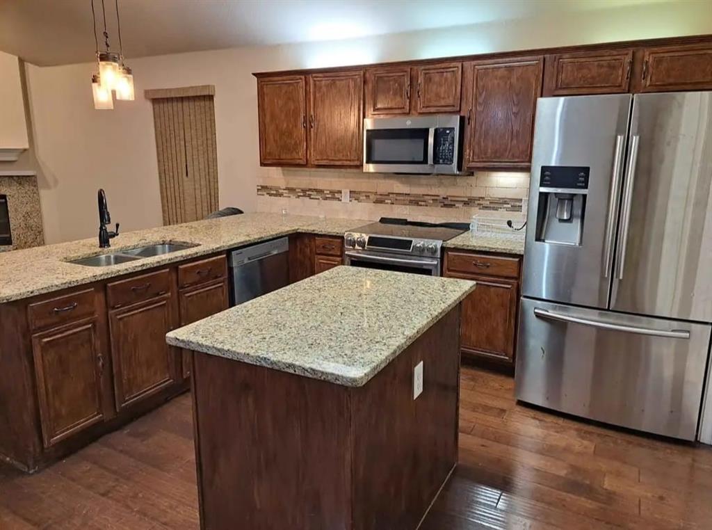 5326 Creek Court Garland, TX 75043 - Photo 4 of 6 a kitchen with kitchen island a sink refrigerator and microwave