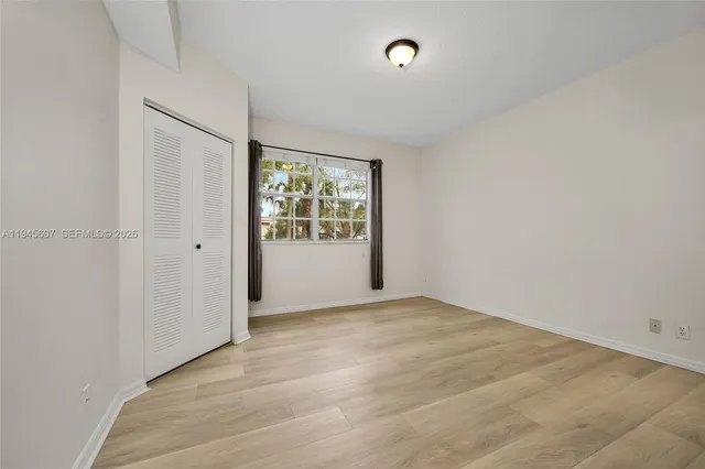 an empty room with windows and closet