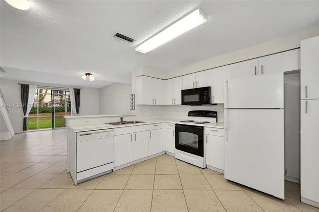 a large kitchen with stainless steel appliances granite countertop a stove a sink and a refrigerator