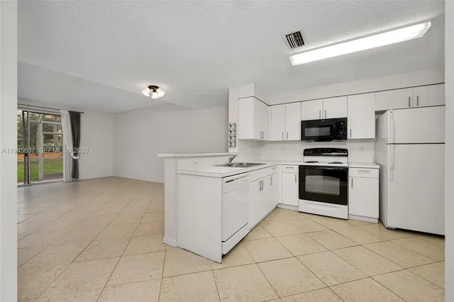 a kitchen with a sink and white cabinets