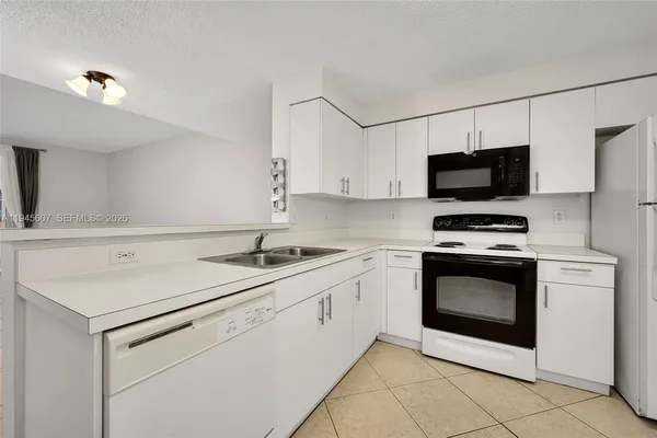 a kitchen with appliances a sink and cabinets