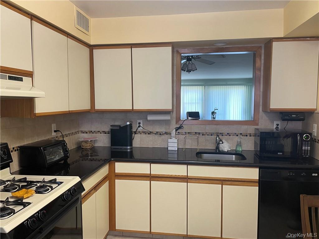 135 West Nyack Road, Unit 93 Nanuet, NY 10954 - Photo 5 of 12 a kitchen with stainless steel appliances granite countertop a sink a stove and a microwave