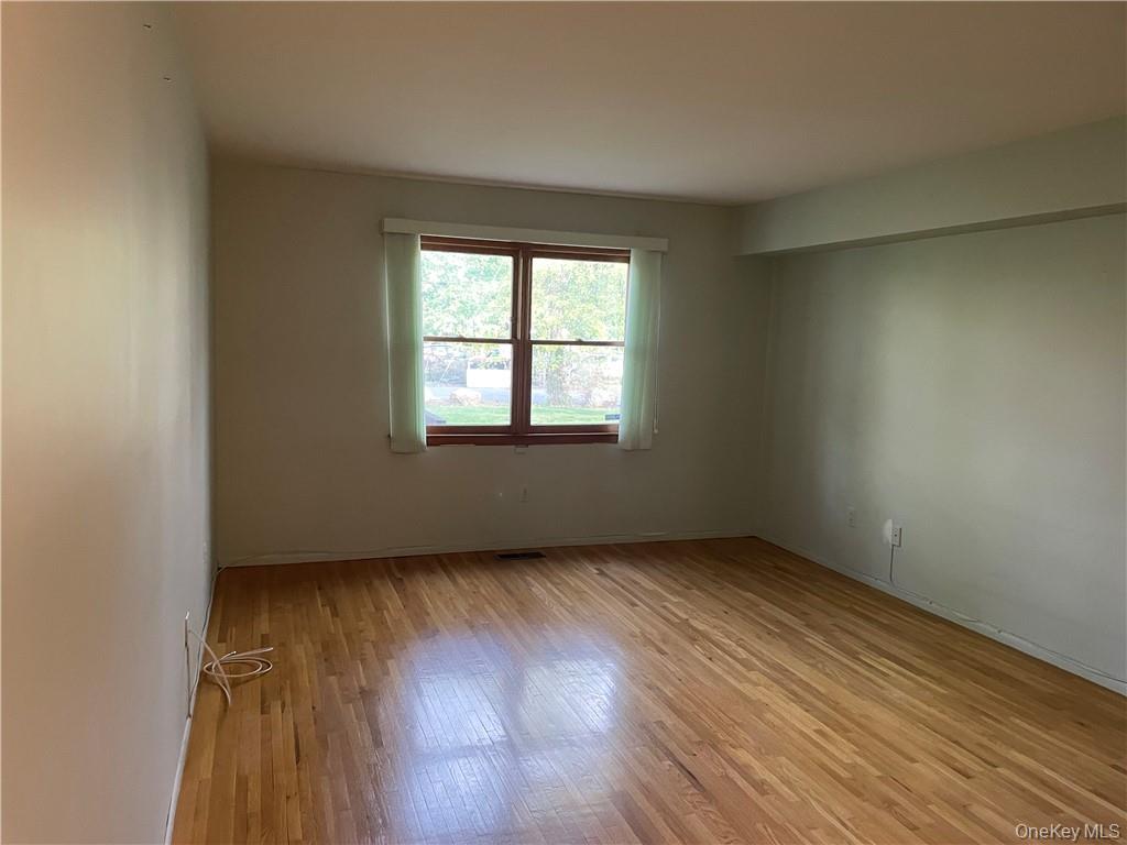 135 West Nyack Road, Unit 93 Nanuet, NY 10954 - Photo 8 of 12 an empty room with wooden floor and windows
