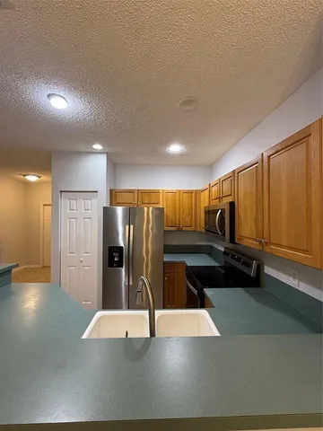 a kitchen with stainless steel appliances granite countertop a sink a stove and a refrigerator
