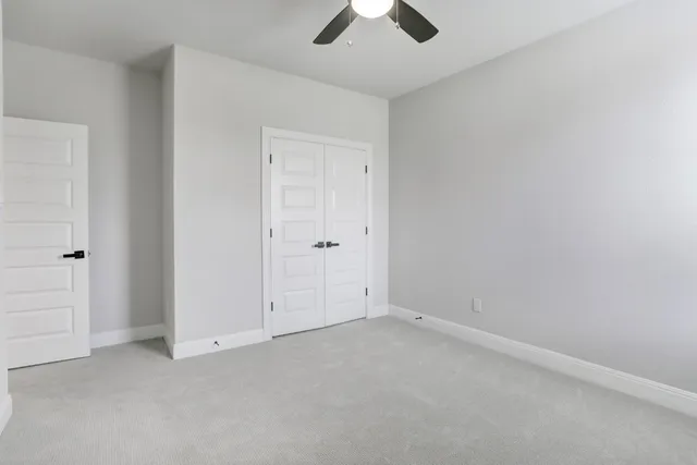 an empty room with chandelier fan