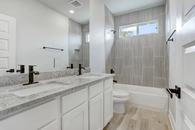 a bathroom with a granite countertop sink toilet and shower