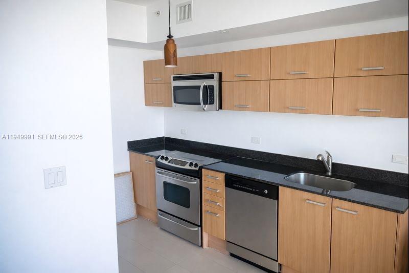 350 South Miami Avenue, Unit 2215 Miami, FL 33130 - Photo 8 of 20 a kitchen with stainless steel appliances granite countertop a sink and a stove