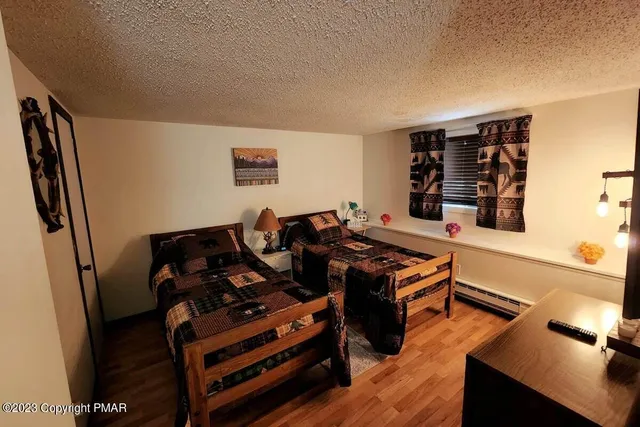 a black leather couch sitting in a living room next to a window