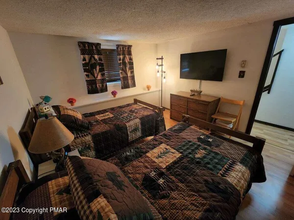 a bedroom with two beds and a flat screen tv