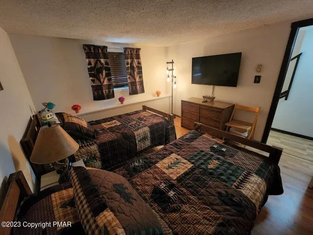 a bedroom with two beds and a flat screen tv