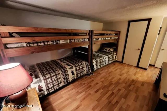 a bedroom with bed and wooden floor