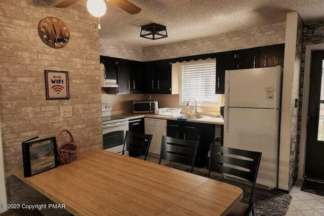 a kitchen with a refrigerator and a stove top oven