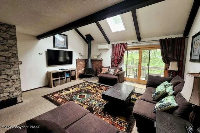 a living room with furniture a flat screen tv and a floor to ceiling window