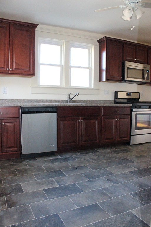 463 Boston Road Billerica, MA 01821 - Photo 7 of 19 a kitchen with stainless steel appliances granite countertop a stove a sink and a microwave