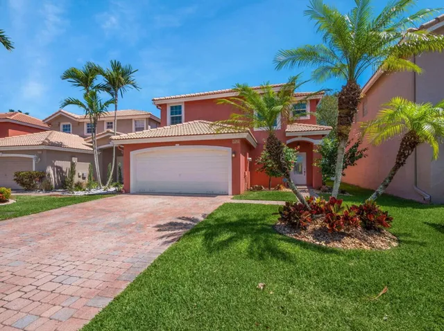a front view of a house with a garden and a yard