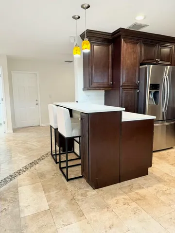 a kitchen with stainless steel appliances a refrigerator and a stove top oven