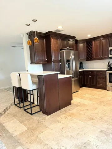 a living room with furniture a flat screen tv and kitchen view
