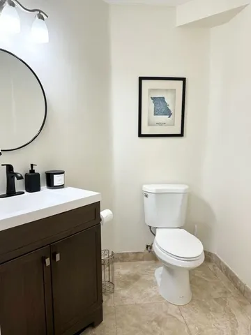 a bathroom with a toilet a sink and mirror