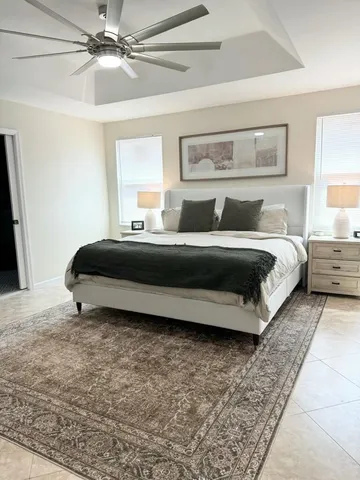 a spacious bedroom with a bed and a chandelier