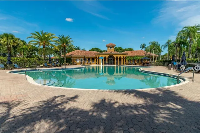 a view of a swimming pool with a patio and plants