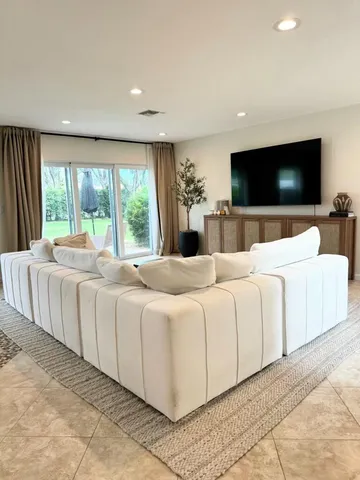 a large bedroom with a large bed and a flat screen tv