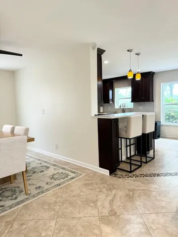 a living room with kitchen island furniture and a flat screen tv