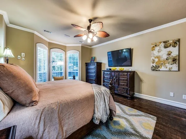 a spacious bedroom with a bed and a flat screen tv