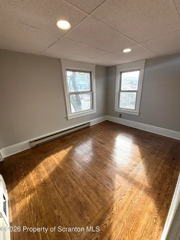 a view of room with window and wooden floor
