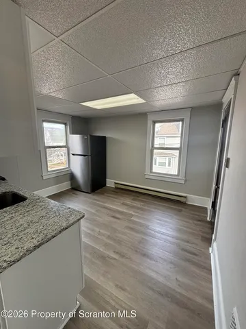 a view of empty room with wooden floor and window