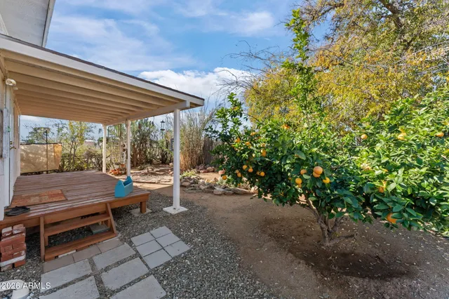 a view of a patio with table and chairs potted plants with wooden floor and fence