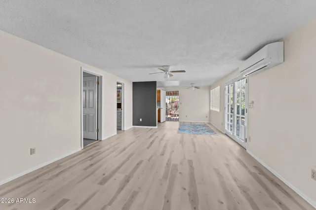 a view of a hallway with wooden floor and a bathroom