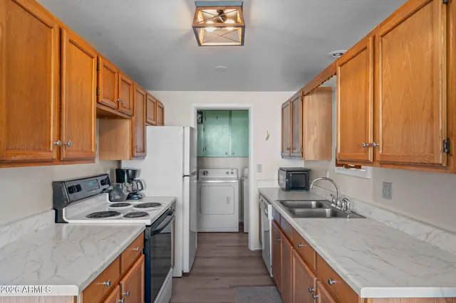 a kitchen with a sink stove top oven and refrigerator
