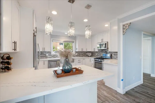 a kitchen with kitchen island granite countertop a sink cabinets and stainless steel appliances