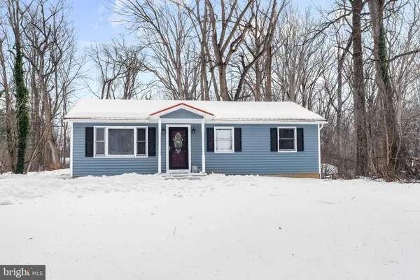 a front view of a house with a yard covered in snow