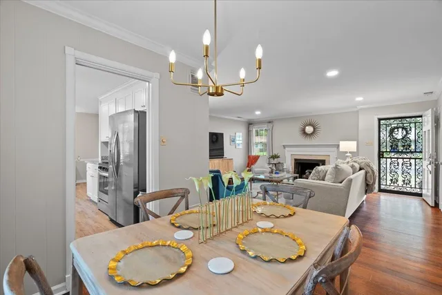 a view of a dining room with furniture a fireplace and wooden floor