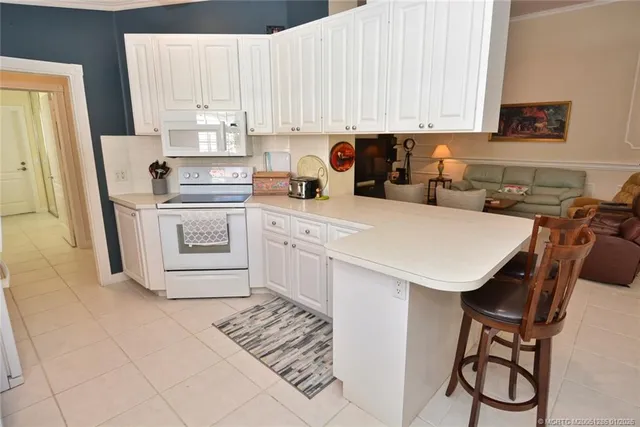 a kitchen with a white appliances a sink and a refrigerator