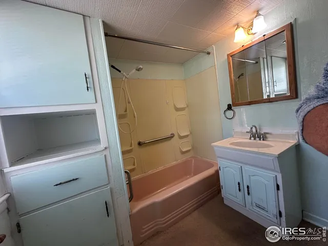 a bathroom with a tub a sink and a mirror