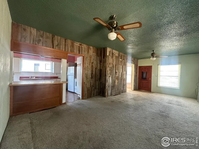 a view of an empty room with window and cabinet