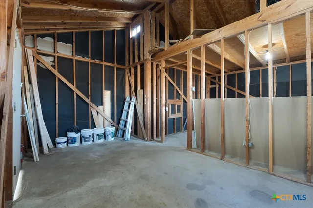 a view of an empty room with wooden floor and windows