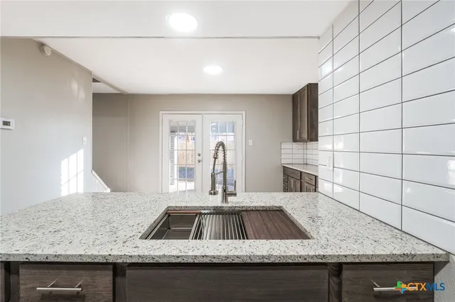 a kitchen with stainless steel appliances granite countertop a sink and a granite counter tops
