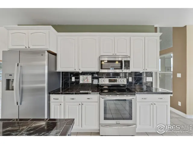 a kitchen with stainless steel appliances a stove a sink a refrigerator and cabinets