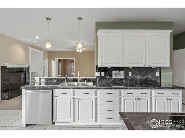 a kitchen with granite countertop a sink a stove and cabinets